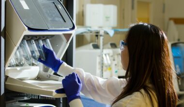 Especialista mulher em Patologia Clínica e Medicina Laboratorial devidamente paramentada analisando amostras biológicas em um laboratorio.